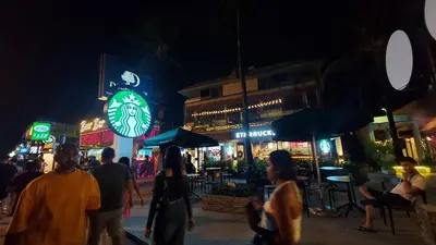 a group of people walking down a street at night at Sawasdee Apartment Patong in Patong Beach