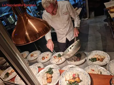a chef preparing food on plates on a table at Villa 242 - private pool, fast internet in Ban Thalat Choeng Thale