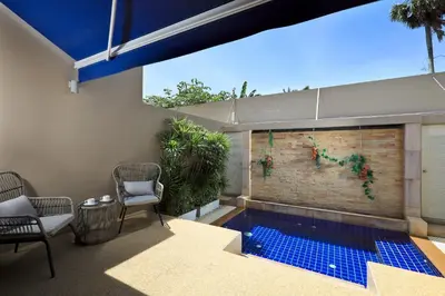 a patio with a swimming pool and two chairs and a building at Villa 242 - private pool, fast internet in Ban Thalat Choeng Thale
