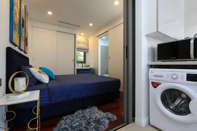 a bedroom with a bed and a washing machine at Villa 242 - private pool, fast internet in Ban Thalat Choeng Thale