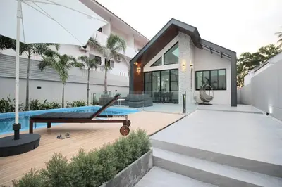 a house with a swimming pool and an umbrella at Stylish Pool Villa - 10 Minutes walk to the Beach in Kamala Beach