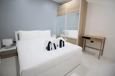 a white bed with black towels on it in a room at Stylish Pool Villa - 10 Minutes walk to the Beach in Kamala Beach