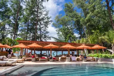 a pool at a resort with umbrellas and chairs at Stylish Pool Villa - 10 Minutes walk to the Beach in Kamala Beach
