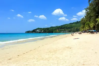 a beach with people and the ocean and trees at Stylish Pool Villa - 10 Minutes walk to the Beach in Kamala Beach