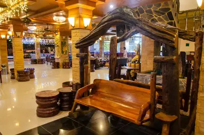 a wooden bench in a building with a restaurant at Diva Patong Hotel in Patong Beach