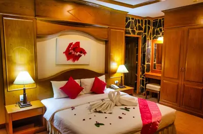 a bedroom with a large bed with red pillows at Diva Patong Hotel in Patong Beach