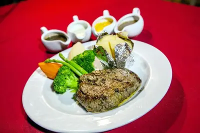 a plate of food with broccoli and vegetables on a red table at Phi Phi Banyan Villa in Phi Phi Don