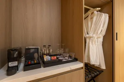 a room with a shelf with a toaster and glasses at Laya Resort Phuket in Layan Beach