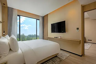 a bedroom with a large white bed and a large window at Laya Resort Phuket in Layan Beach