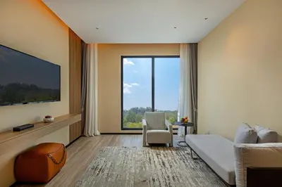 a living room with a couch and a large window at Laya Resort Phuket in Layan Beach