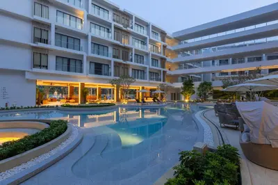 a swimming pool in front of a building at Laya Resort Phuket in Layan Beach