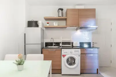a kitchen with a washing machine and a refrigerator at The Lago Apartments in Ban Suan