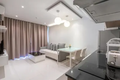 a living room with a couch and a table at The Lago Apartments in Ban Suan