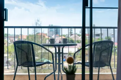 two chairs and a table on a balcony at The Lago Apartments in Ban Suan