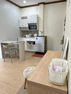 a kitchen with a table and a white refrigerator at Kata Noi Place floor3 in Kata Beach