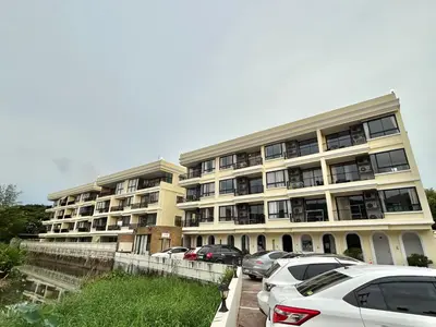 a large building with cars parked in front of it at Cozy 2 bedrooms walk to Nai Harn beach in Rawai Beach
