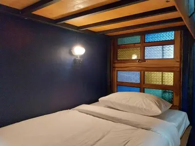 a bedroom with a bed and a window at W168 hostel in Ban Lo Long