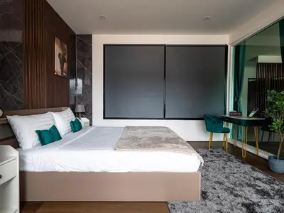 a bedroom with a large bed and a desk at Grand Penthouse by Grand Orlov Apart in Patong Beach