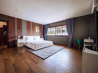 a bedroom with a white bed and a large window at Grand Penthouse by Grand Orlov Apart in Patong Beach