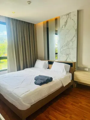 a bedroom with a large white bed with a window at 2 bed room the lago naiharn beach in Nai Harn Beach