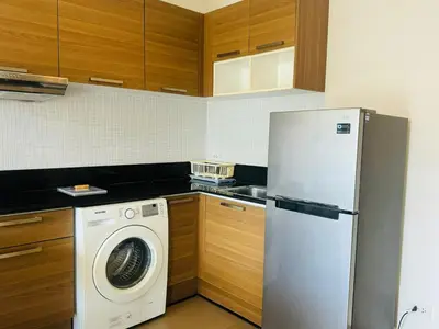 a kitchen with a refrigerator and a washing machine at 2 bed room the lago naiharn beach in Nai Harn Beach