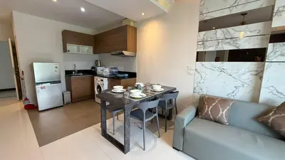 a kitchen with a table and a couch in a room at 2 bed room the lago naiharn beach in Nai Harn Beach