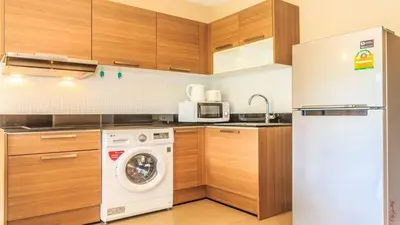 a kitchen with a white refrigerator and a washing machine at 2 bed room the lago naiharn beach in Nai Harn Beach