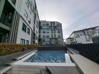 a building with a fountain in the middle of a city at Zcape1 boat avenue in Ban Thalat Choeng Thale