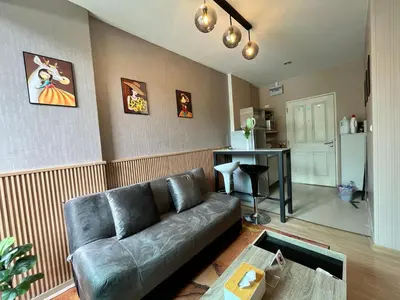 a living room with a leather couch and a kitchen at Zcape1 boat avenue in Ban Thalat Choeng Thale