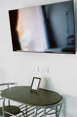 a tv hanging on a wall above a green table at Sasimanta in Kamala Beach