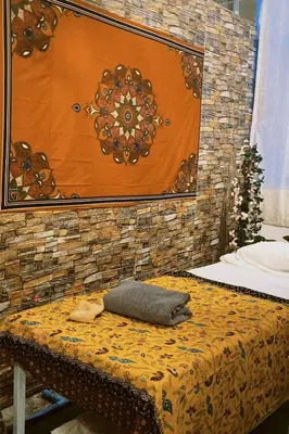 a room with a bed with a stone wall at Sasimanta in Kamala Beach
