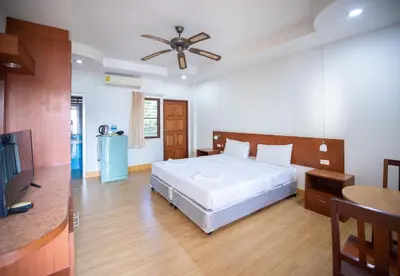 a bedroom with a bed and a ceiling fan at G house guest house in Patong Beach