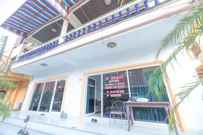 a restaurant with a table and a chair in front of a window at G house guest house in Patong Beach