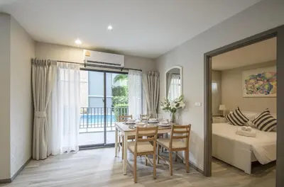 a dining room with a table and a bedroom at 2 Bedrooms Suite Pool Access@The Title Residencies Naiyang in Nai Yang Beach