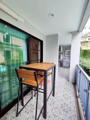 a table and chair in a room with a balcony at 2 Bedrooms Suite Pool Access@The Title Residencies Naiyang in Nai Yang Beach