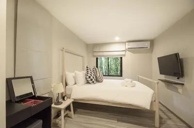 a bedroom with a white bed and a television at 2 Bedrooms Suite Pool Access@The Title Residencies Naiyang in Nai Yang Beach