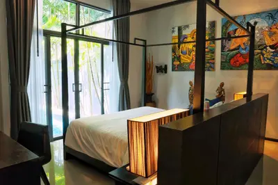 a bedroom with a canopy bed and a window at Villa Casablanca in Ban Saiyuan (1)