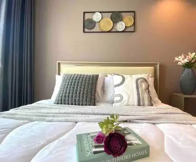 a bedroom with a bed with a book on it at Sky park 2 BR lake view in Bang Tao Beach