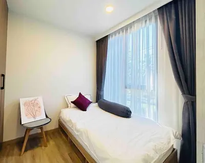 a small bedroom with a bed and a window at Sky park 2 BR lake view in Bang Tao Beach