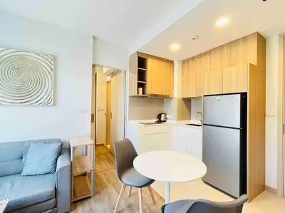 a living room with a couch and a table and a kitchen at Sky park 2 BR lake view in Bang Tao Beach