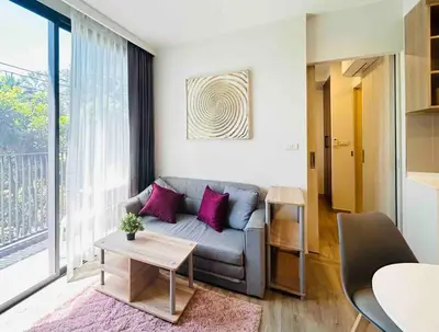a living room with a couch and a table at Sky park 2 BR lake view in Bang Tao Beach