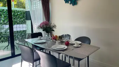 a dining room table with chairs and a table with food on it at Townhouse in the Wonderland in Bang Tao Beach
