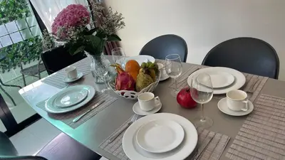 a table with plates and glasses and a bowl of fruit at Townhouse in the Wonderland in Bang Tao Beach