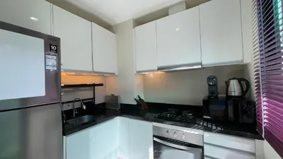 a kitchen with white cabinets and black counter tops at Townhouse in the Wonderland in Bang Tao Beach