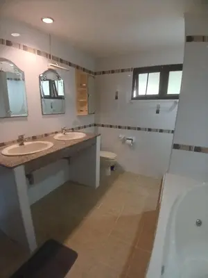 a bathroom with two sinks and a toilet and a tub at Aksarai hotel in Patong Beach