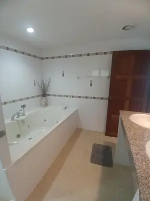 a white bathroom with a tub and a sink at Aksarai hotel in Patong Beach