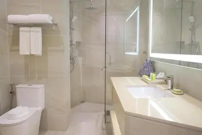 a bathroom with a shower and a toilet and a sink at Wyndham Garden Naithon Phuket in Nai Thon Beach
