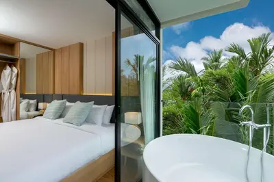 a bedroom with a white bed and a large window at Wyndham Garden Naithon Phuket in Nai Thon Beach