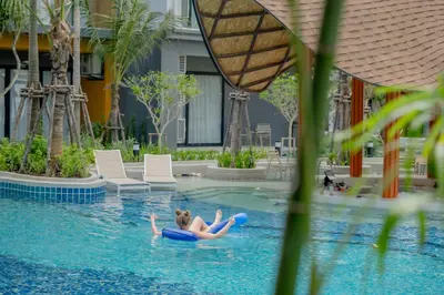 a woman laying on a raft in a swimming pool at Wyndham Garden Naithon Phuket in Nai Thon Beach