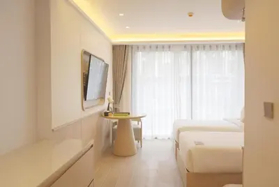 a hotel room with a bed and a table at Wyndham Garden Naithon Phuket in Nai Thon Beach